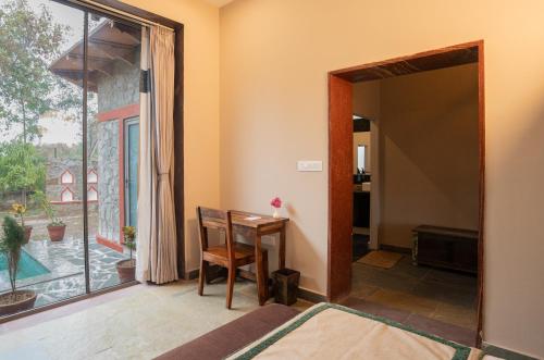 a dining room with a table and a large window at Neem Sarai Sariska in Tehla