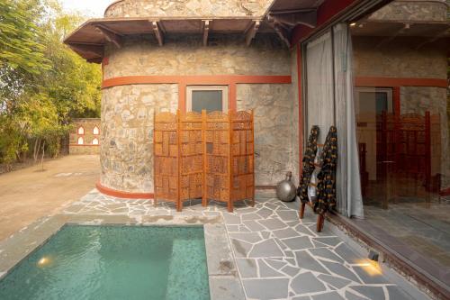 a house with a swimming pool next to a building at Neem Sarai Sariska in Tehla