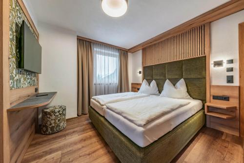sypialnia z dużym łóżkiem i telewizorem w obiekcie Montana Apartments w Mayrhofen