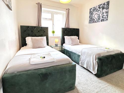 2 camas en una habitación pequeña con faldas en Colchester City Luxury With Free Parking and 5 G WIFI, en Colchester