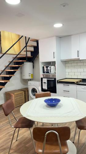 a kitchen with a table and chairs and a staircase at Casa da Ti Paqueta in Sabugal