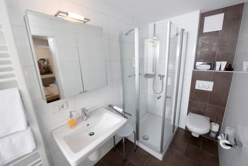 a bathroom with a sink and a shower and a toilet at Franziskaner in Würzburg