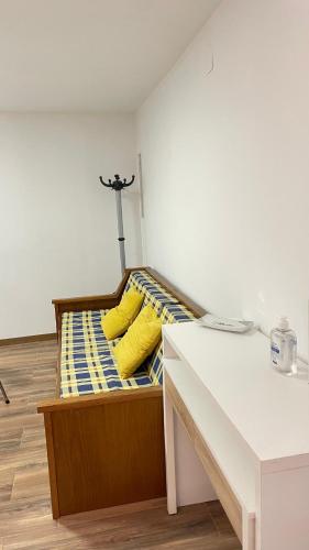a bed with yellow pillows in a room at Casa da Ti Paqueta in Sabugal