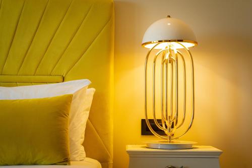 a lamp on a night stand next to a bed at Santa Lucia Boutique Hotel in Santa Luċija