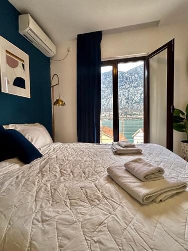 a bedroom with a large bed with towels on it at Apartments Marković in Kotor