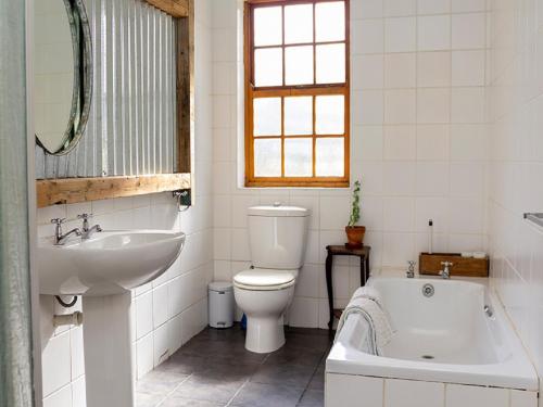 a bathroom with a tub and a toilet and a sink at Beloftebos Farm Cottages in Papiesvlei