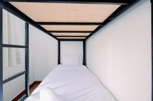 a bed in a small room with a ceiling at Best Deal and Comfort Designed 2BR Transpark Cibubur Apartment By Travelio in Depok