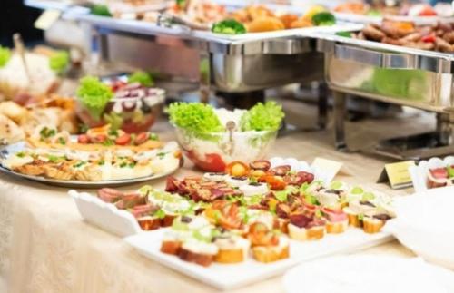 a buffet with several plates of food on a table at Pensiunea Petra- Clisura Dunarii in Divici