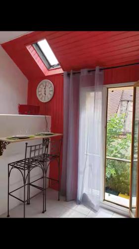 a room with a clock and a table and a window at Studio Indépendant 5 min gare in Nogent-lʼArtaud