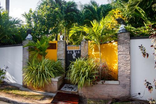 a garden in front of a white fence with plants at Nid'Aigle Lodge in Anse Possession
