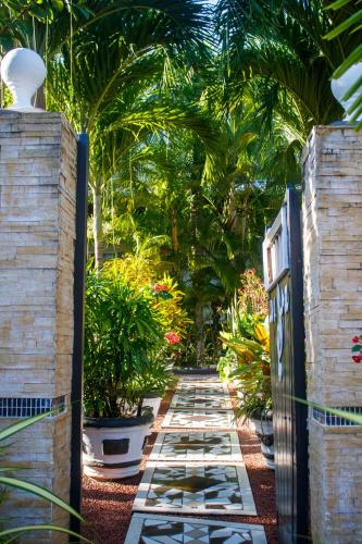 a gate to a garden with plants and palm trees at Nid'Aigle Lodge in Anse Possession