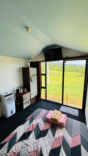 a bedroom with a bed with a view of a field at Gayana Hills in Ciater