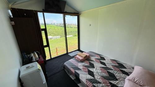 a bedroom with a bed and a large window at Gayana Hills in Ciater
