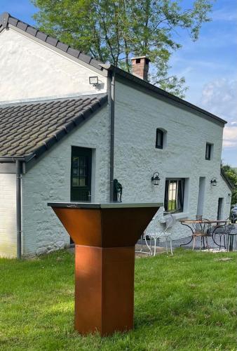 a podium in front of a house with a table at La Petite Maison Blanche in Wanze
