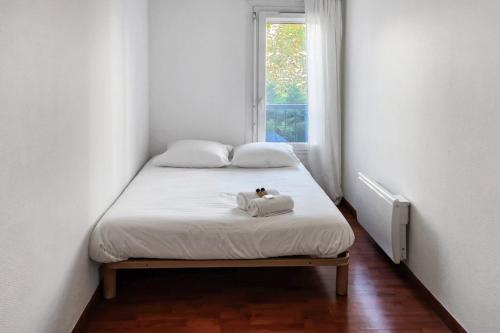 un lit dans une petite pièce avec une fenêtre dans l'établissement Cosy Charpennes, à Villeurbanne