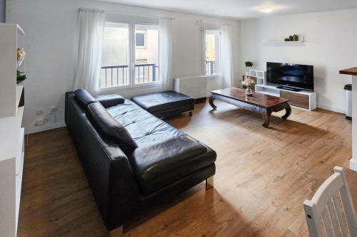 - un salon avec un canapé en cuir et une table basse dans l'établissement Cosy Charpennes, à Villeurbanne