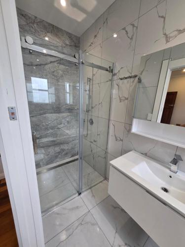a bathroom with a glass shower and a sink at Villa 191 in Masterton