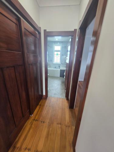 a hallway of a bathroom with wooden floors and doors at Villa 191 in Masterton