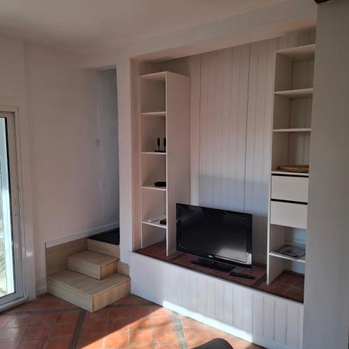 - un salon avec une télévision et des étagères dans l'établissement Le six cent dix huit, à Mauves-sur-Loire