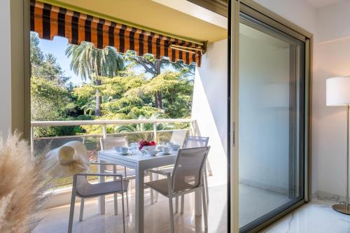 une salle à manger avec une table et des chaises et une grande fenêtre dans l'établissement Spacious 2-Br Apartment in a Residence with Pool, à Cannes
