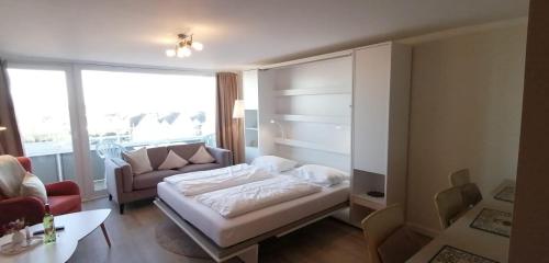 a living room with a bed and a couch at Hanseatenhaus in Westerland (Sylt)