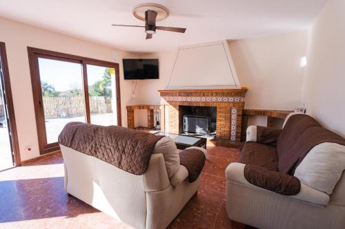 a living room with two couches and a fireplace at Casa Rural VILLA ADRISEDA in Constantina