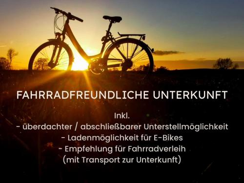 a bike parked in front of the sunset at ALTE SCHULE WITTENBERG, 3 Ferienwohnungen für bis zu 12 Personen, an der Elbe, mit Garten in Lutherstadt Wittenberg