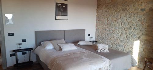 a bedroom with a large bed with a stone wall at Agriturismo La Pina in Tarzo