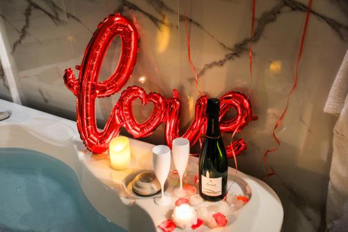 a heart shaped balloon with a bottle of wine and candles at Villa Bono Jacuzzi & Spa in Saint-Laurent-du-Var