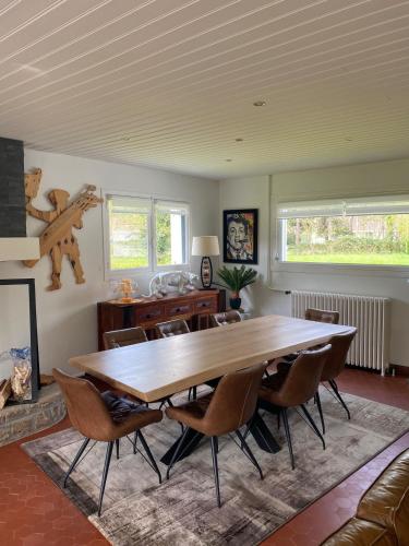 une salle à manger avec une grande table et des chaises en bois dans l'établissement Belle propriété très bon emplacement, à Le Touquet-Paris-Plage
