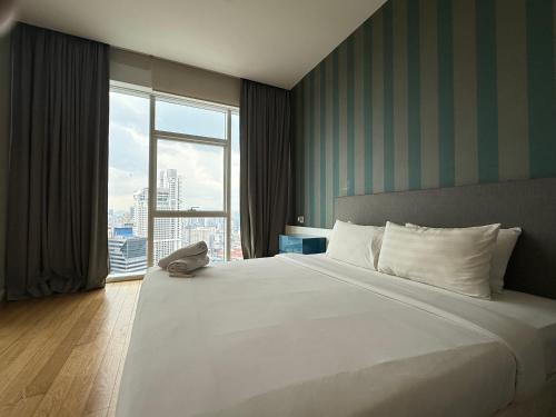 Un dormitorio con una cama grande con una ventana grande. en Platinum Premier Suite KLCC, en Kuala Lumpur