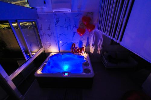 a bathroom with a jacuzzi tub with purple lighting at Villa Bono Jacuzzi & Spa in Saint-Laurent-du-Var