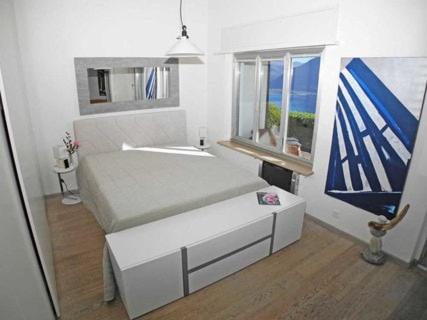 a white room with a bed and a window at Casa Helios - traumhafte Seesicht, Jacuzzi, Sauna in Orselina