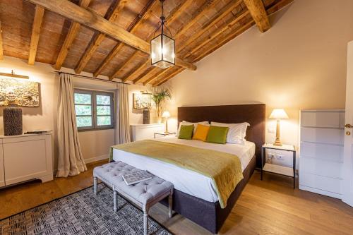 a bedroom with a large bed and a wooden ceiling at Luxury Villa Acquaviva Firenze in Montauto