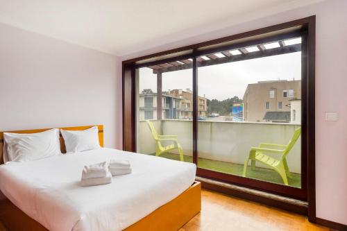 a bedroom with a bed and a large window at GuestReady - Comfortable Retreat in Esposende in Marinhas