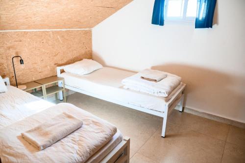 a small room with two beds and a window at The White Hill Guesthouse in Yeroẖam