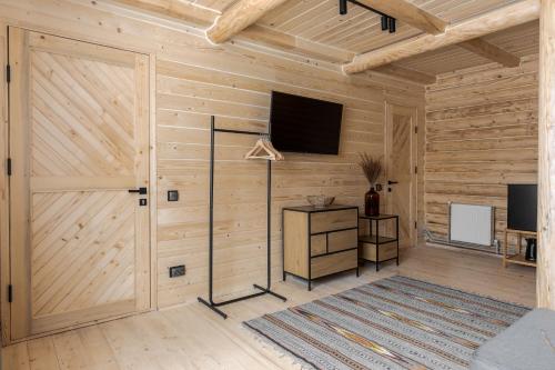 a room with a wooden wall with a tv on it at Gremi Hotel in Dragobrat