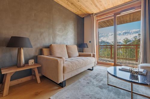 un salon avec un canapé et une table en verre dans l'établissement Apartment Nuna, Méribel - by EMERALD STAY, à Les Allues