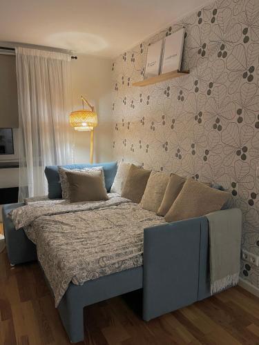 a blue bed in a room with a wall at Otepää Boho Home in Otepää