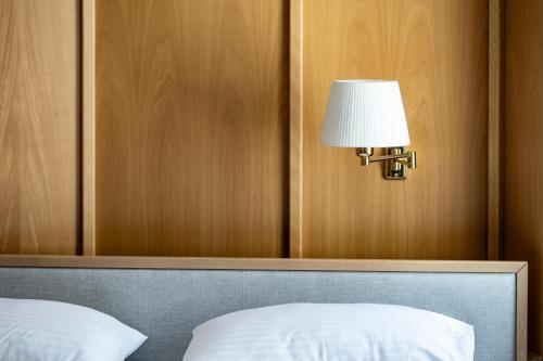 a lamp on a wall above a bed at Sporthotel am Semmering in Semmering