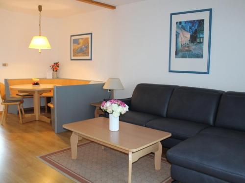 un salon avec un canapé et une table dans l'établissement Ferienhaus Nr 70, Kategorie Komfort, Feriendorf Hochbergle, Allgäu, à Bichel
