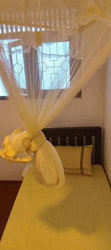 a bedroom with a bed with a curtain on it at Sharta Unawatuna Hostel in Unawatuna