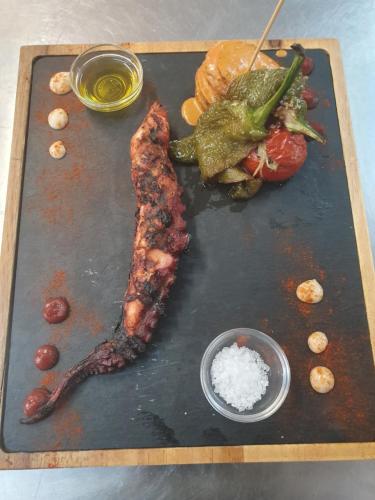 a tray of food with meat and a sandwich and sauce at Apartamento Nuevo Ondina in Begur