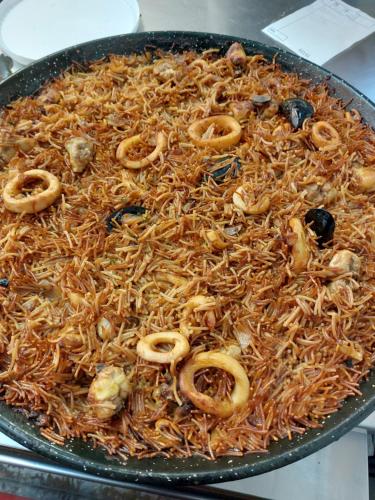a pan filled with noodles and other food at Apartamento Nuevo Ondina in Begur