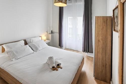 une chambre avec un lit avec deux ours en peluche dessus dans l'établissement Charpennes Cocooning, à Villeurbanne