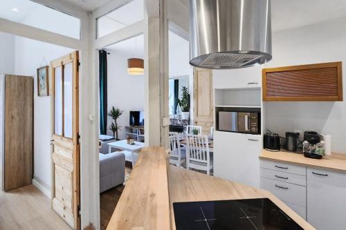 une cuisine et un salon avec une grande fenêtre dans l'établissement Charpennes Cocooning, à Villeurbanne