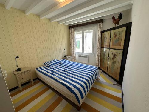a bedroom with a bed with a blue and white striped floor at Maison de ville sur 2 niveaux - 2 chambres - terrasse tropézienne in Saintes-Maries-de-la-Mer