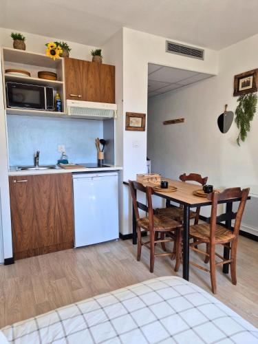 une cuisine et une salle à manger avec une table et des chaises dans l'établissement BelleÉtoile - Wifi - Clim - Vue, à Lourdes