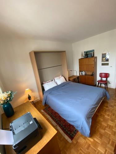 - une chambre avec un lit et une table avec une télévision dans l'établissement Comfort, bright and view Eiffel Tower - Levallois, à Levallois-Perret