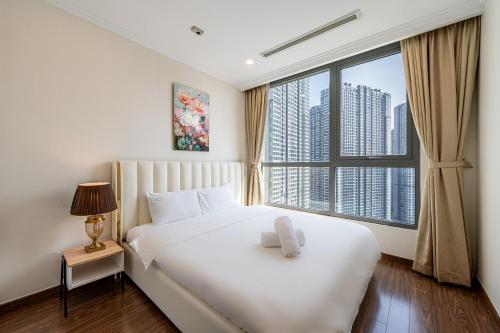 a bedroom with a white bed with a large window at Vinhomes Central Park Apartment - Landmark Plus Luxury in Ho Chi Minh City